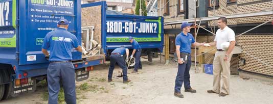 Truck team members loading junk on 1800-GOT-JUNK? trucks
