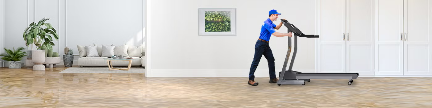 1800-GOT-JUNK? Truck Team Member hauling away a treadmill