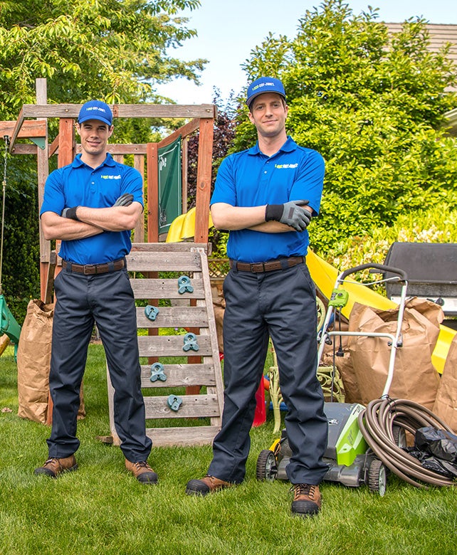 Two Truck Team Members hauling away lawn equipment