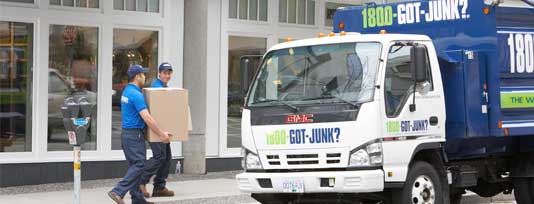 Two truck team members carrying boxes to the truck